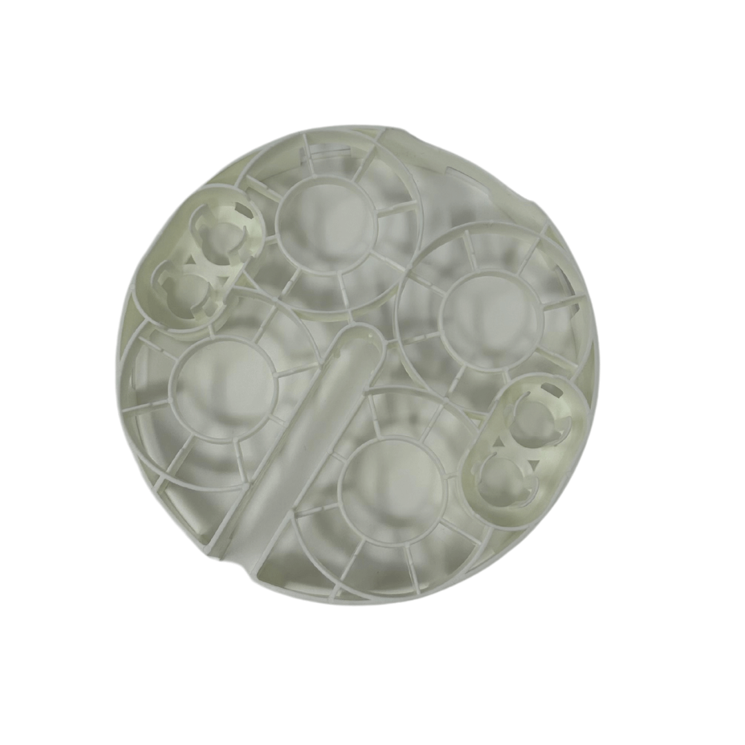 A top view of the Baby Brezza UK Bottle Washer Replacement Bottle Rack, a round, translucent plastic rack with multiple circular and oval compartments, shown against a white background. - product thumbnail