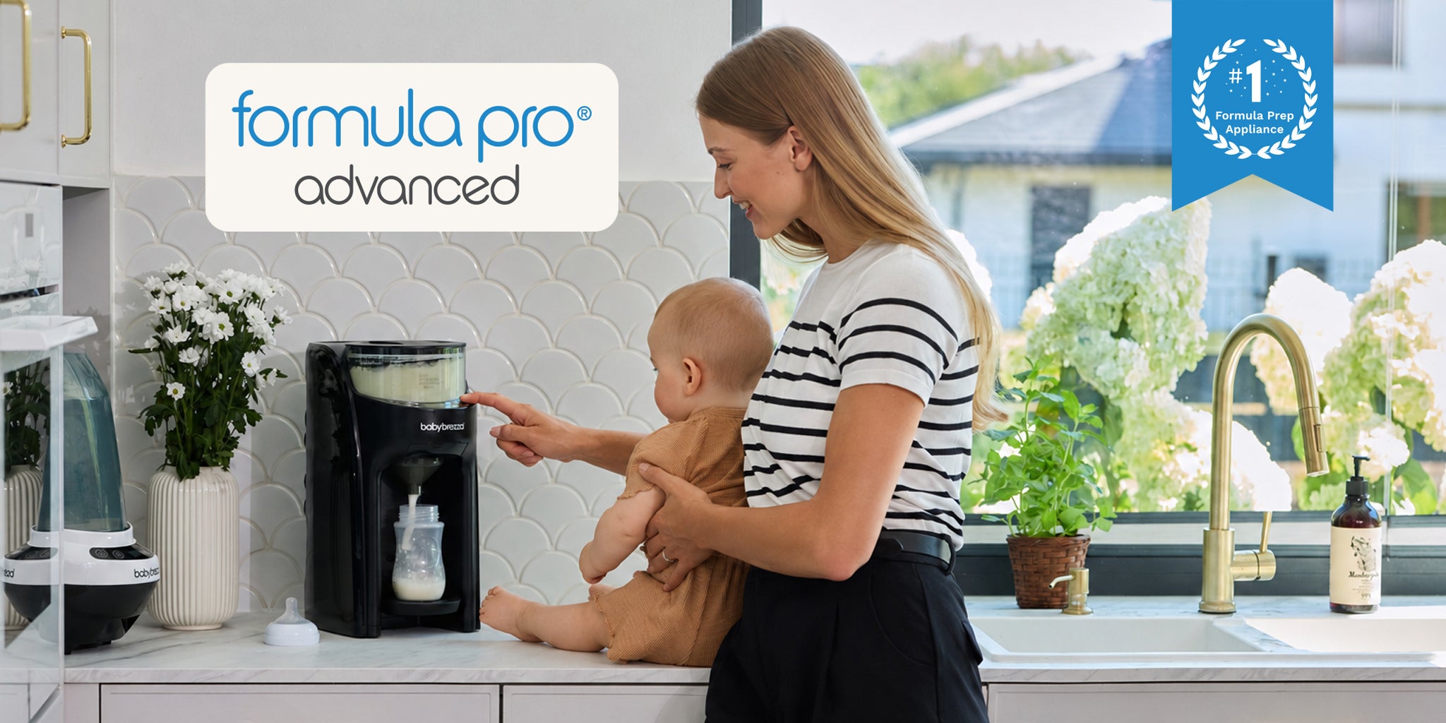 A woman in a kitchen holds a baby while using a black Formula Pro Advanced bottle dispenser. The scene includes promotional text overlays for 'formula pro advanced' and a blue 'number 1 formula prep appliance' badge.