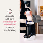A person holds a bottle above a Baby Brezza UK Bottle & Breastmilk Warmer on a kitchen counter. Text highlights its precise, safe warming and auto shut-off to prevent overheating. - product thumbnail