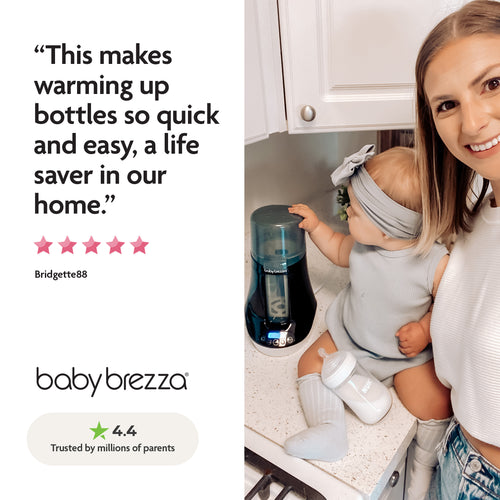 A smiling woman holds a baby in a kitchen by the Baby Brezza UK Baby Brezza BUNDLE Steriliser Dryer Advanced Black And Bottle & Breast Milk Warmer, with a parent testimonial and 4.4-star rating shown on the left. - product thumbnail
