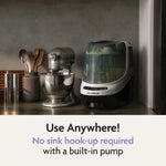 The Baby Brezza UK Bottle Washer Pro – All In One Washer, Steriliser, Dryer sits beside a mixer and utensils. Use anywhere! Its built-in pump means no sink hook-up needed—ideal for washing and sterilising baby bottles. - product thumbnail