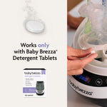 A hand loads bottles and parts into the Baby Brezza UK Bottle Washer Pro - All In One Washer, Steriliser, Dryer. Text says: Works only with Baby Brezza Detergent Tablets. Image shows a tablet and a 120-count box of detergent tablets. - product thumbnail