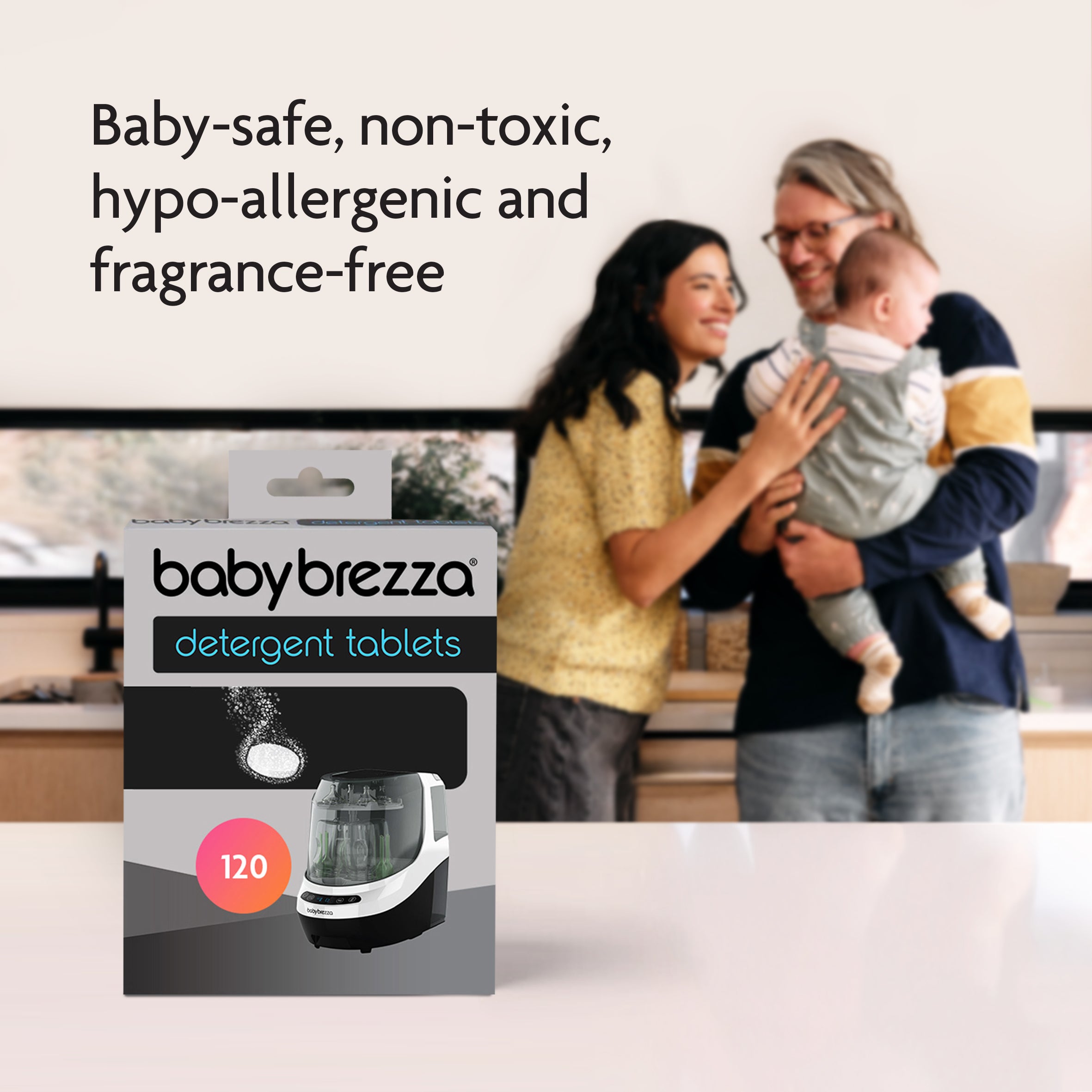 A happy couple holds their baby in a cozy home. In front, a box of Baby Brezza UK Detergent Tablets for Bottle Washer Pro® (120 Tablets) appears. Text: Baby-safe, non-toxic, hypo-allergenic & fragrance-free—ideal for safe cleaning. - product thumbnail