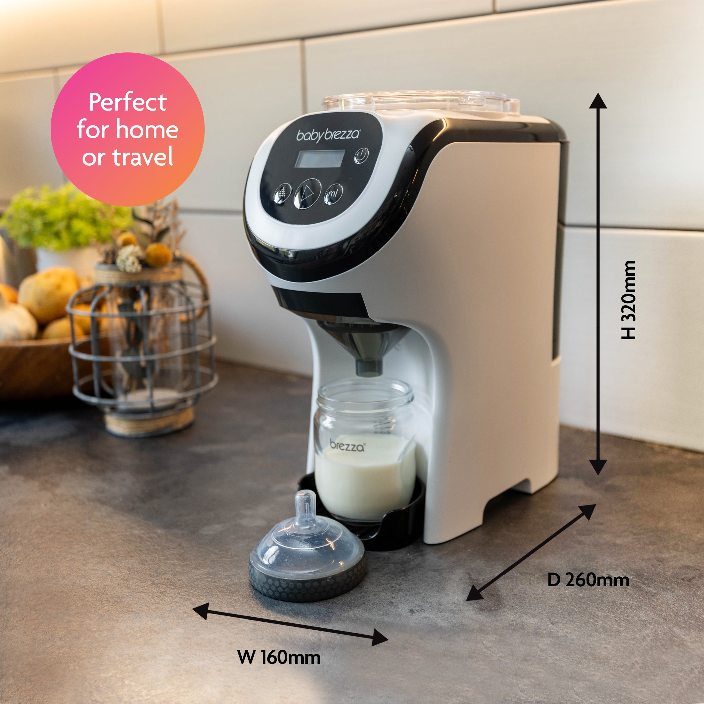 The Baby Brezza UK Formula Pro Mini sits compactly on your kitchen counter with a bottle under the dispenser. Arrows show its dimensions: H 320mm, D 260mm, W 160mm. Text reads: Perfect for home or travel. - product thumbnail