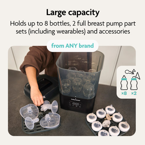 A person loads breast pump parts into the Baby Brezza BUNDLE Formula Pro Advanced And SuperQuick Steriliser - All Black, which holds up to 8 bottles, 2 full breast pump sets, and accessories from any brand. Ideal for use with your bottle maker. - product thumbnail