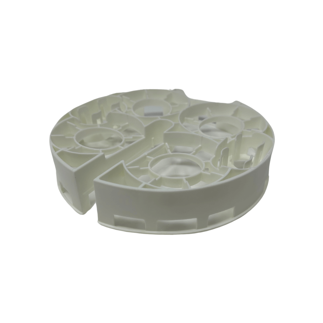 The Baby Brezza UK Bottle Washer Replacement Bottle Rack is a round, white plastic rack with multiple compartments and openings, designed for the Bottle Washer Pro. It features intricate structural details and a smooth finish. - product thumbnail