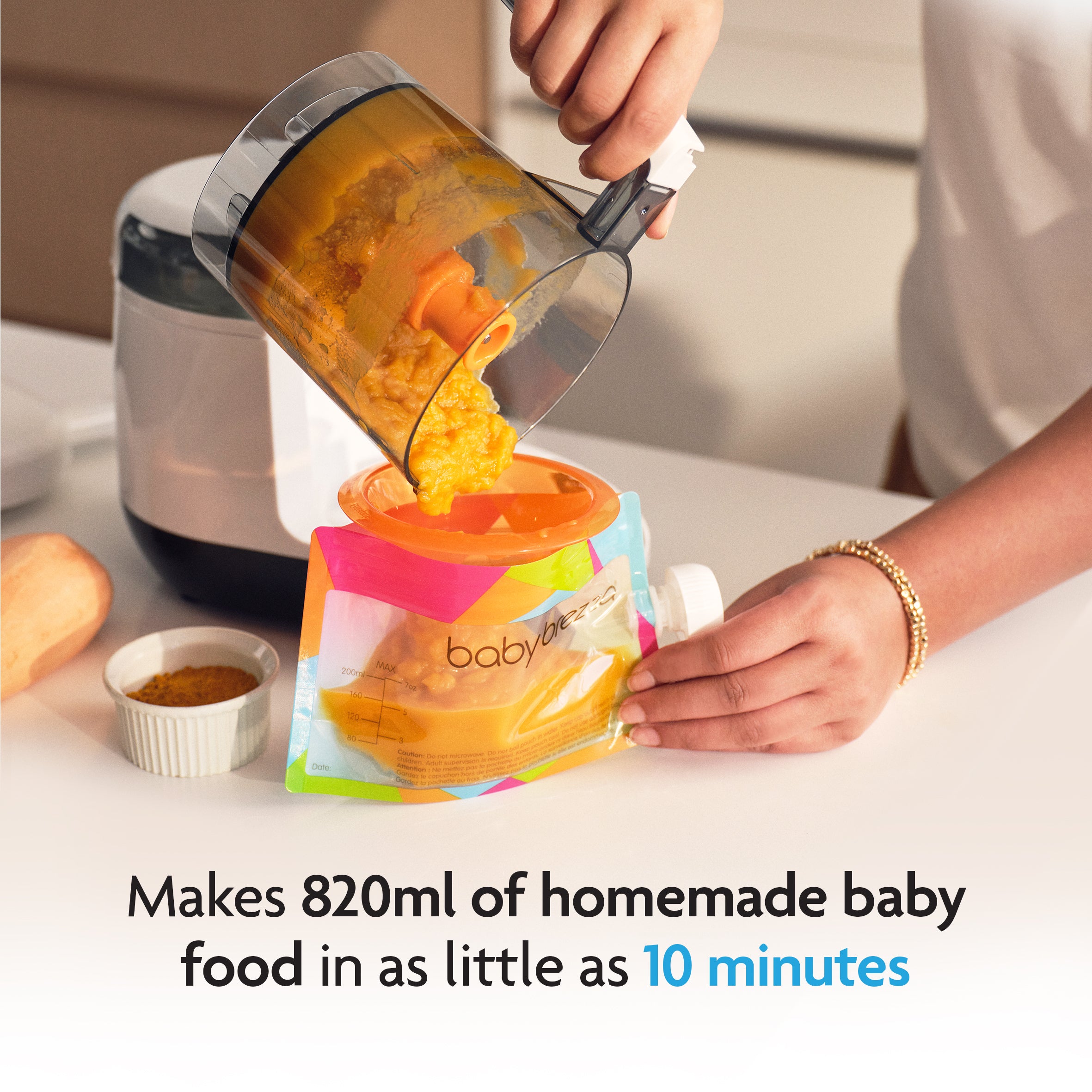 A person uses the Baby Brezza UK BIG BREZZA BUNDLE - Formula Pro Advanced, Bottle Washer Pro + MUCH MORE! - White to make up to 820ml of homemade baby food in just 10 minutes, pouring it into a colorful pouch in a kitchen by the bottle washer. - product thumbnail