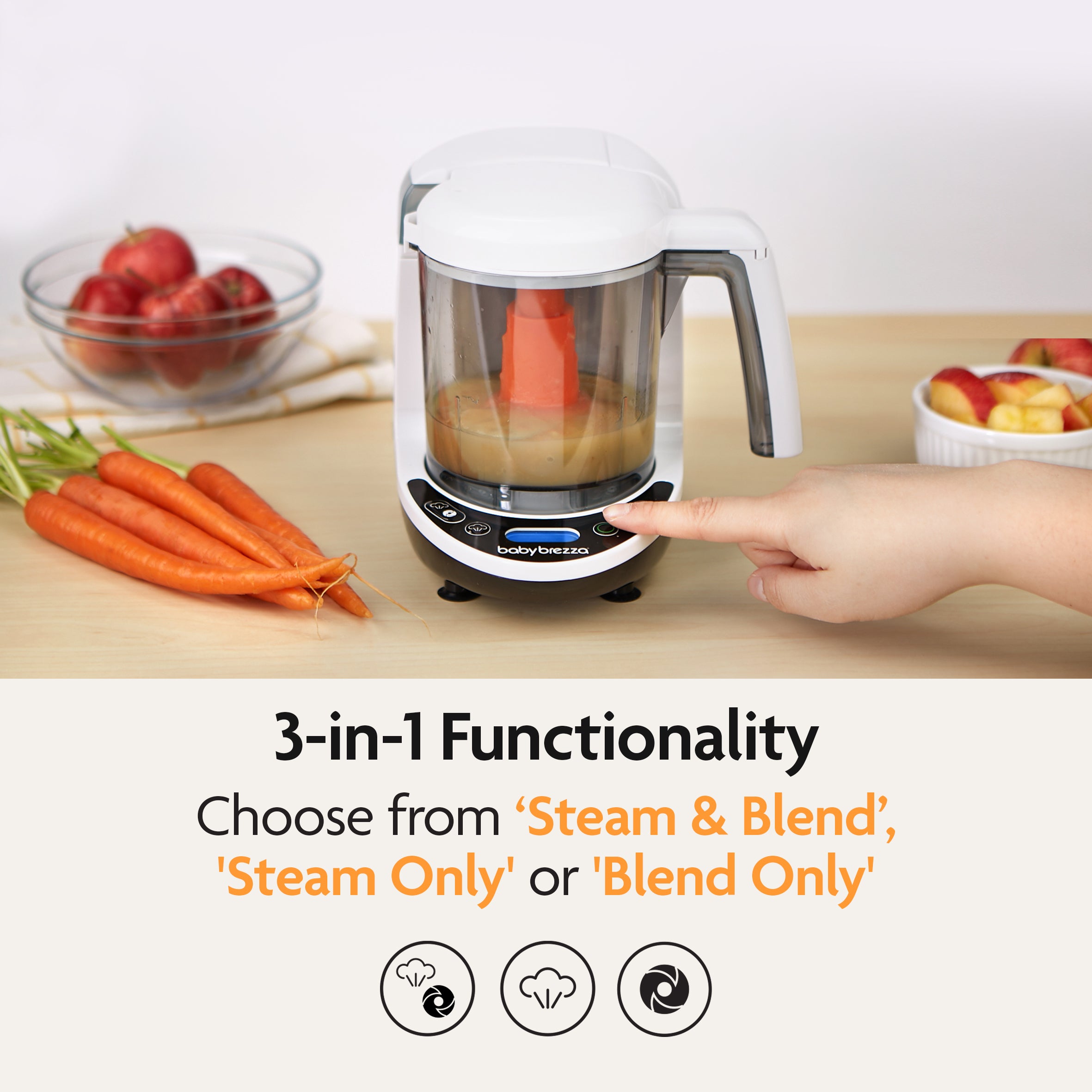 A hand presses a button on the Baby Brezza UK One Step Food Maker Deluxe, filled with pureed food, making homemade baby food preparation effortless. Fresh carrots and apples sit nearby. Text reads: 3-in-1 Functionality—choose Steam & Blend, Steam Only, or Blend Only. - product thumbnail
