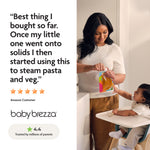 A woman uses the Baby Brezza UK One Step Food Maker Deluxe + FREE Pouches to steam pasta and veggies in her kitchen while her baby sits nearby. A 4.4-star rating and logo are shown, with reviews praising its homemade baby food prep. - product thumbnail