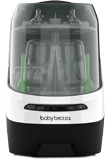 A Baby Brezza baby bottle sterilizer and dryer with a transparent lid revealing bottles and accessories inside, labeled with the brand name on the front.